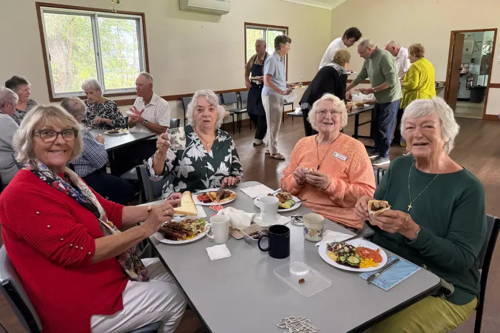 Church community members seated together for a shared meal in Abbey Hall