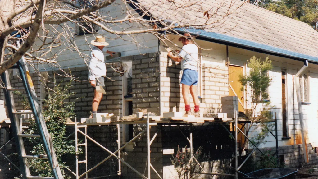 Two Members Laying The History of the Abbey Community Brick by Brick