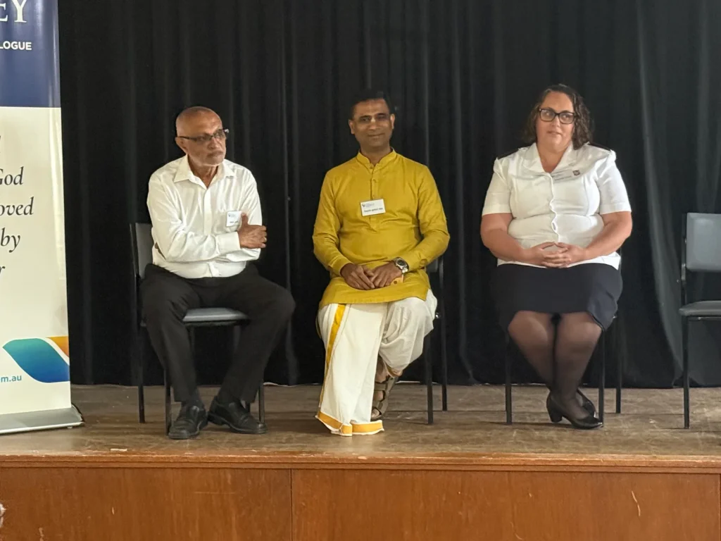 Three speakers from different faith traditions seated on stage for an Exploration of Faith Series panel