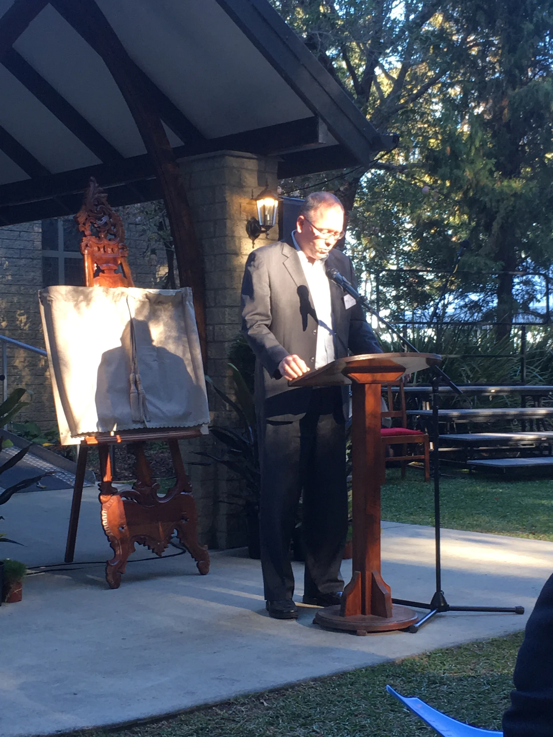 Speaker at an outdoor lectern during the Centre's 2018 interfaith launch in the Abbey grounds