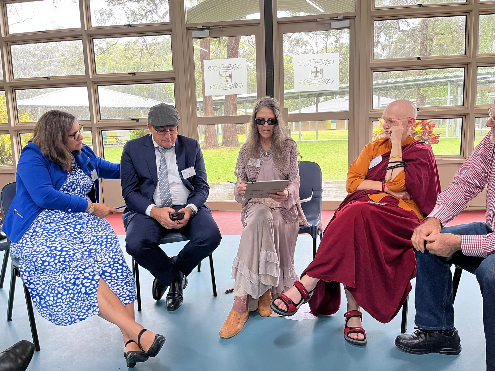 Workshop participants from several faith traditions, including a Buddhist nun, in a facilitated discussion circle at an Abbey multi faith symposium